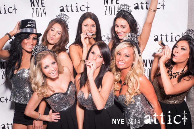 lovely hostesses pose on the step and repeat background for New Years Eve 2014 party at the Attic
