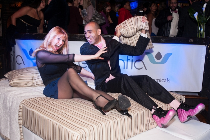 Cute couple pillow fights at a private photo activation for Essentia Mattresses, House of Blues Chicago 