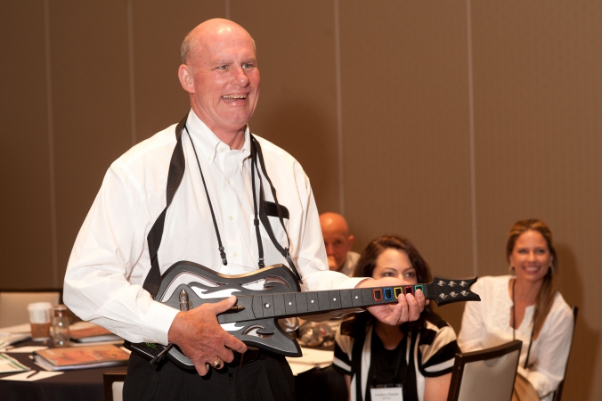 man plays rock band, break out session photo, team building games, merck product launch, rosemont convention center