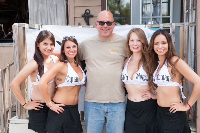 The captain morgan booth babes pose with lucky fan at white rum liquor promotion, photo activation fab photo.