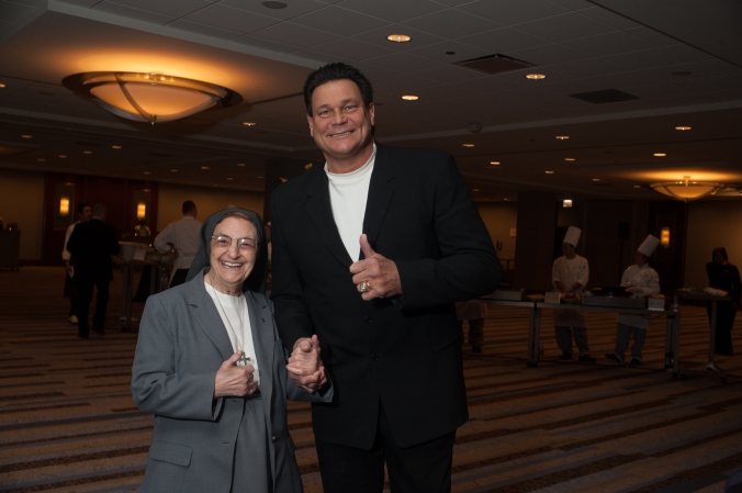 Dan Hampton poses with one of the nuns at the annual fundraiser dinner and silent auction for presence health, event photography by fab photo.