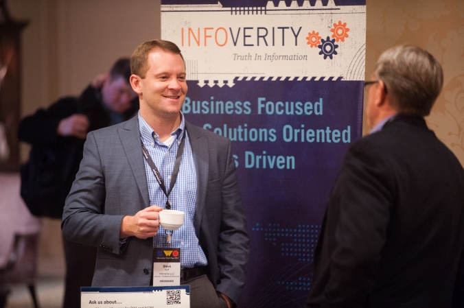 Networking conversation, sponsor table at tech conference