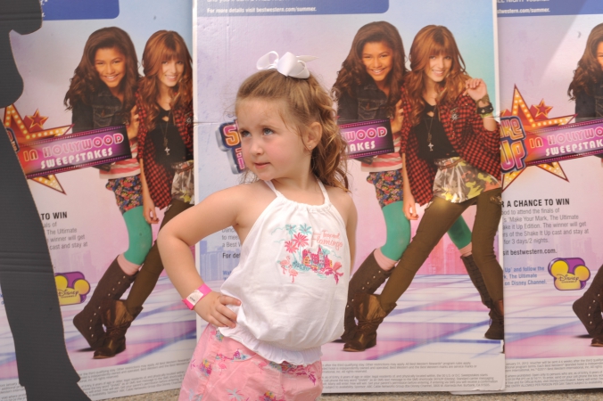 young girl poses with attitude on the step and repeat, disney tv show promotion at mall